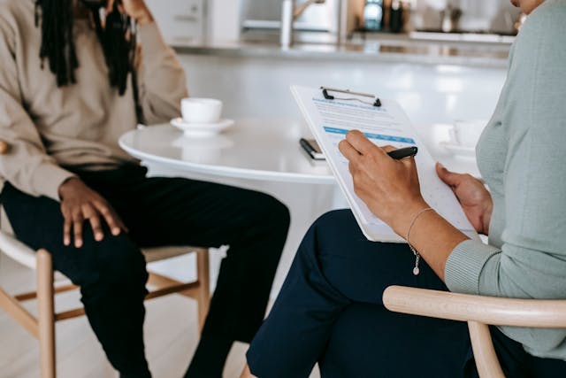 Person with a clipboard sitting across from another person